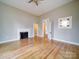 Sunlit living room featuring an original fireplace, hardwood flooring, and classic trim at 613 S Mulberry St, Statesville, NC 28677
