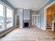 Bright living room features hardwood floors, a fireplace, and an open doorway leading to the upper level of the home at 613 S Mulberry St, Statesville, NC 28677
