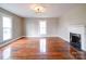 Spacious living room featuring hardwood floors, fireplace, and ample natural light from large windows at 613 S Mulberry St, Statesville, NC 28677