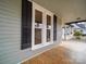 Detailed porch view with window with black shutters and wooden floors at 613 S Mulberry St, Statesville, NC 28677