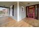Inviting porch view showcasing wooden floors, a pink-trimmed front door, and black shutters at 613 S Mulberry St, Statesville, NC 28677
