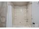 Bathroom features a bathtub with white shower curtain, built-in shelves, and modern fixtures at 7977 Lucky Creek Ln, Denver, NC 28037