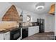 Kitchen boasts white cabinets, black appliances, and unique architectural details above countertops at 7977 Lucky Creek Ln, Denver, NC 28037