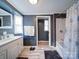 Well-lit bathroom featuring gray walls, a white vanity, and a bathtub with a decorative shower curtain at 1075 Fye Dr, Newton, NC 28658