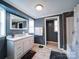 Modern bathroom with blue walls, white vanity, and tub/shower combo with tile surround at 1075 Fye Dr, Newton, NC 28658