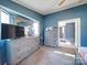 A blue bedroom with carpet and gray wood furniture with a bright natural light flowing in from the window at 1075 Fye Dr, Newton, NC 28658
