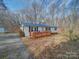 Charming home featuring a blue roof, new deck, and manicured landscaping at 1075 Fye Dr, Newton, NC 28658