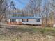Charming home featuring a blue roof, new deck, and manicured landscaping at 1075 Fye Dr, Newton, NC 28658