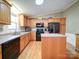 Functional kitchen featuring wood cabinets, a center island, black appliances, and plenty of counter space and natural light at 1075 Fye Dr, Newton, NC 28658
