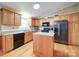 Bright kitchen featuring wood cabinets, a center island, black appliances, and plenty of counter space and natural light at 1075 Fye Dr, Newton, NC 28658