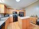 Functional kitchen featuring wood cabinets, a center island, black appliances, and plenty of counter space and natural light at 1075 Fye Dr, Newton, NC 28658