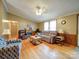 Inviting living room features a cozy fireplace, plush sofa, wood-paneled wall, and lots of natural light from the double windows at 1075 Fye Dr, Newton, NC 28658