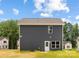 Exterior of the home showcasing gray siding, white trim, with a door leading to the backyard at 1124 Thayer Glen Ct, Charlotte, NC 28213