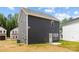 View of the home's side and backyard, featuring gray siding and white trim at 1124 Thayer Glen Ct, Charlotte, NC 28213