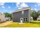 Exterior of the home showcasing gray siding and a backyard with a small patio at 1124 Thayer Glen Ct, Charlotte, NC 28213
