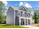 Side view of a gray two-story home with white trim, a cozy front porch, and well-manicured lawn at 1124 Thayer Glen Ct, Charlotte, NC 28213