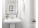 Contemporary powder room featuring pedestal sink, modern fixtures, mirror and decor at 1124 Thayer Glen Ct, Charlotte, NC 28213