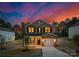 Charming two-story home features a brick-accented facade, inviting front porch, and attached garage with a colorful dusk sky at 1132 Thayer Glen Ct, Charlotte, NC 28213