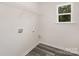 Bright laundry room features wood-look flooring, convenient shelving and a window for natural light at 1132 Thayer Glen Ct, Charlotte, NC 28213