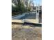 Construction site showing a foundation with gravel fill, set against a backdrop of trees and buildings at 115 Verbena Ne St # 12, Charlotte, NC 28217