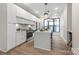 This open kitchen boasts stainless steel appliances, white cabinets, an island, and pendant lights at 115 Verbena Ne St, Charlotte, NC 28217