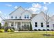Two-story white farmhouse exterior with landscaping and large windows at 13109 Brooklyn Skylar Way, Huntersville, NC 28078