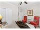 Bright bedroom with a ceiling fan, natural light from the large window, and two comfy chairs at 145 Jacobs Woods Cir, Troutman, NC 28166