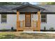 Modern farmhouse exterior with a wood-toned front porch and white brick facade at 1600 Academy St, Charlotte, NC 28205