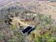 Aerial view of house and outbuildings on a wooded lot at 1745 Badin Lake Rd, New London, NC 28127