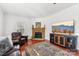 Cozy living room with hardwood floors, fireplace, ceiling fan and a large TV on a wooden cabinet at 1745 Badin Lake Rd, New London, NC 28127