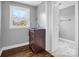 Bathroom with dark wood vanity, marble shower, and gray walls at 201 Ware St, Shelby, NC 28150
