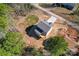 An aerial view of a cozy two-story home featuring a spacious yard surrounded by lush trees and a private driveway at 2204 Hillcrest Ave, Albemarle, NC 28001