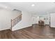 Open living room with hardwood floors, staircase, and bright kitchen in a newly constructed home at 2204 Hillcrest Ave, Albemarle, NC 28001
