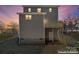Rear of home with a wooden deck and staircase, offering privacy and natural beauty at 2204 Hillcrest Ave, Albemarle, NC 28001