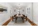The dining room features a modern chandelier, neutral colors, and hardwood floors to offer a perfect space for entertaining at 2809 Glendale Rd, Charlotte, NC 28209