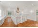 Spacious upstairs hallway featuring hardwood floors, a statement chandelier, and built-in shelving at 2809 Glendale Rd, Charlotte, NC 28209