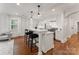 A spacious kitchen features a central island, stainless steel appliances, custom lighting and hardwood flooring at 2809 Glendale Rd, Charlotte, NC 28209