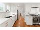 A renovated kitchen features white cabinets, stainless steel appliances, stone countertops, and hardwood flooring at 2809 Glendale Rd, Charlotte, NC 28209