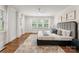 A serene main bedroom featuring hardwood floors, shuttered windows, and a stylish upholstered headboard at 2809 Glendale Rd, Charlotte, NC 28209