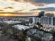 A view of a residential area features homes and apartments buildings as a sunset bursts on the horizon at 287 Mcdonald Ave, Charlotte, NC 28203