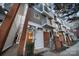 Modern townhouse featuring a brick and gray wood exterior, front door, and small balconies at 287 Mcdonald Ave, Charlotte, NC 28203
