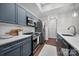 Contemporary kitchen boasts stainless steel appliances, white countertops, gray cabinets and wood-look floors at 287 Mcdonald Ave, Charlotte, NC 28203