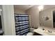 Functional bathroom featuring a shower with a blue and white curtain, a toilet, and a sink with vanity at 3331 Tamworth Ln, Gastonia, NC 28052