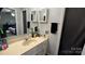 Bathroom with a neutral-toned vanity, a large mirror, and white cabinets with a view into the bedroom at 3331 Tamworth Ln, Gastonia, NC 28052