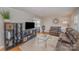 Cozy living area features a large brown sofa, hardwood floors, and stylish shelving for storage at 4001 Glenfall Ave, Charlotte, NC 28210