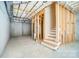 Unfinished basement with exposed beams, insulation and view to staircase at 4114 Thames River Pl, Harrisburg, NC 28075