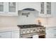 Close-up of stainless steel stove with pot filler and white tile backsplash in modern kitchen at 4114 Thames River Pl, Harrisburg, NC 28075