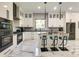 Modern kitchen with white cabinets, marble floors, and breakfast bar at 4129 Carnoustie Ln, Charlotte, NC 28210