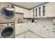 Bright laundry room with white cabinets and modern appliances at 4129 Carnoustie Ln, Charlotte, NC 28210