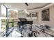 Bright music room with large windows, black baby grand piano, and marble floors at 4129 Carnoustie Ln, Charlotte, NC 28210